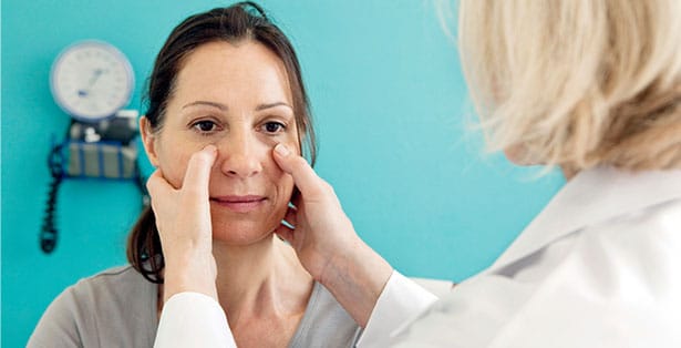 Doctor examining womans nasal inflammation