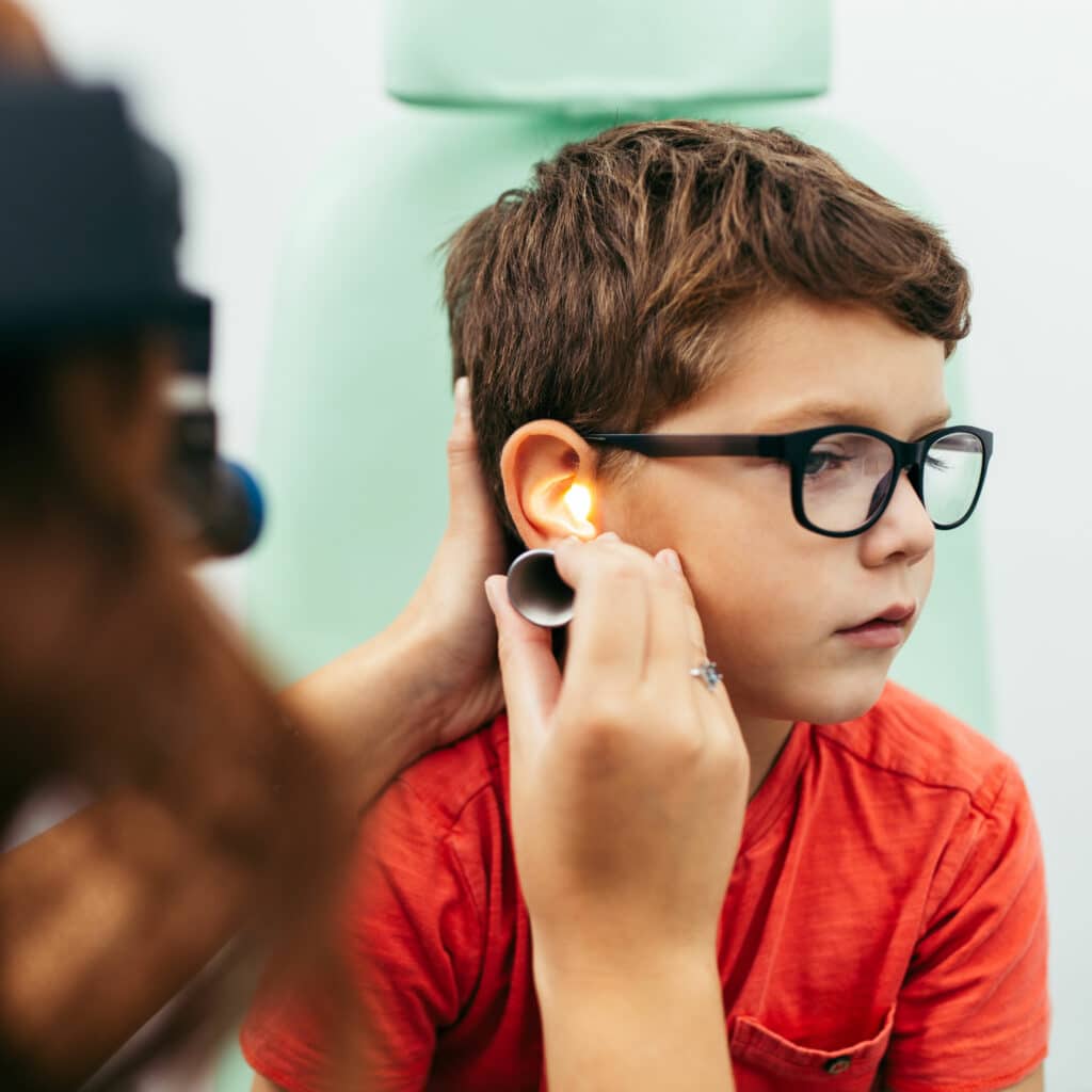 ENT doctor examining young boys ears